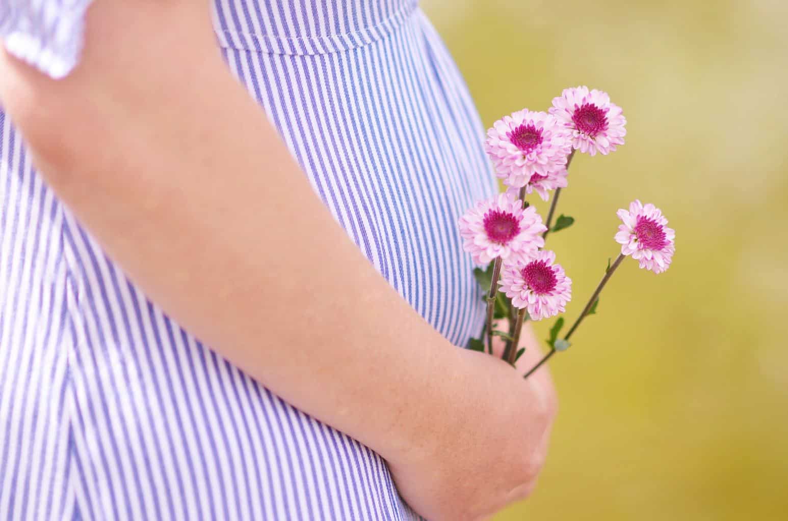 pregnant woman holding flowers