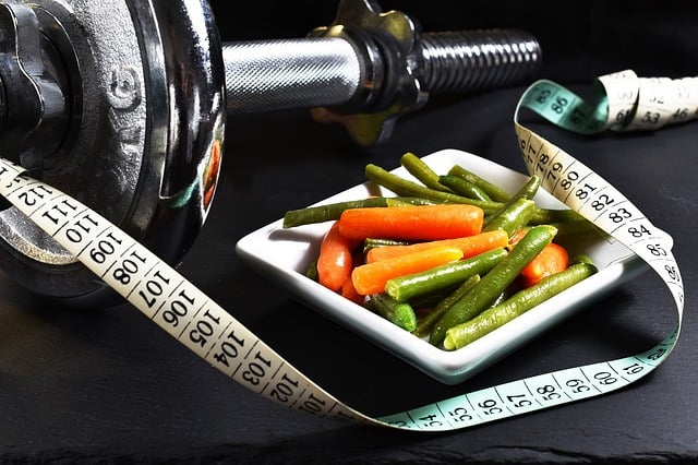 a bowl of vegetables, weights, and a measuring tape