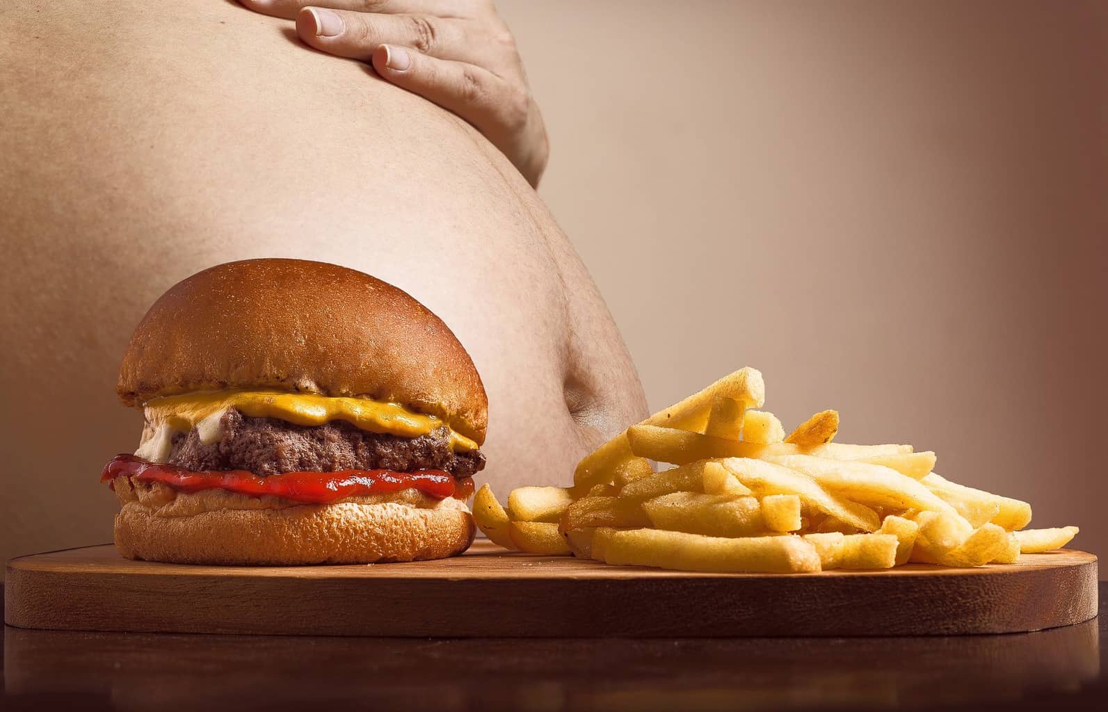 a fat stomach with burger and fries